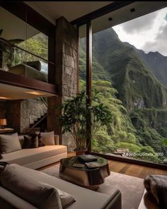 a living room filled with furniture and a large window overlooking the mountain side area in front of it