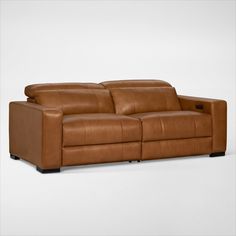 a brown leather couch sitting on top of a white floor