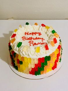 a birthday cake with white frosting and multicolored gummy bears