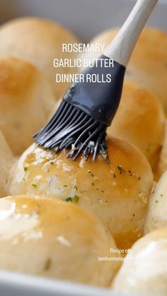 a close up of some rolls with a brush in it's mouth and the words rosemary garlic butter dinner rolls