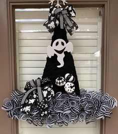 a black and white halloween decoration hanging on a door