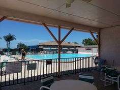 an outdoor swimming pool with tables and chairs