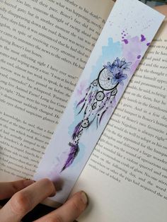 the bookmark is decorated with an image of a dream catcher and flowers on it