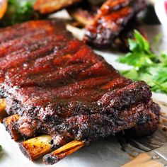 the ribs are covered in barbecue sauce and garnished with parsley