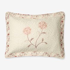 a white pillow with pink flowers on it