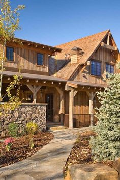 a large wooden house with lots of windows and wood trimmings on the roof