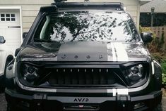 the front end of a black jeep parked in a driveway