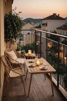 two wicker chairs sitting on top of a wooden deck next to a table with candles