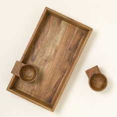 a wooden tray with two bowls on it and one empty bowl in the bottom right hand corner