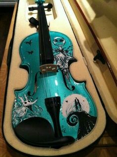 a blue violin sitting on top of a wooden table next to a mirror and wall