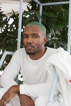 a man sitting down in front of some plants