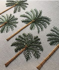 embroidered pine trees on white linen with twine and burlocked stems in the center