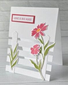 a white card with pink flowers on it and the words love is big hugs written in red