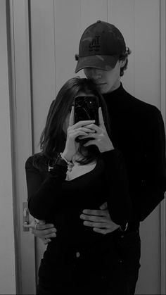 a man and woman taking a selfie in front of a mirror with their arms around each other