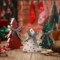 small wooden christmas trees with bows and pine cones in front of them on a table