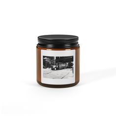 a jar filled with brown liquid sitting on top of a white table next to a black and white photo