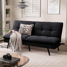 a living room with a couch, coffee table and pictures on the wall