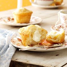 two muffins sitting on top of a white plate next to a cup and saucer