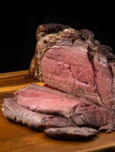 a piece of meat sitting on top of a wooden cutting board next to a knife