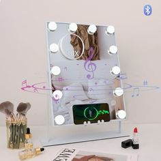 an illuminated vanity mirror with music notes on it and makeup brushes in front of it