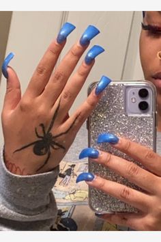 a woman with blue nail polish holding up her phone