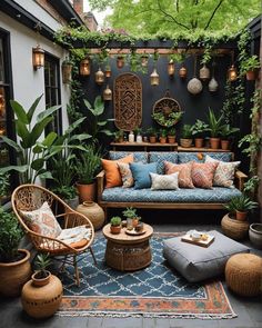 an outdoor living room with plants and potted plants on the walls, couches and rugs