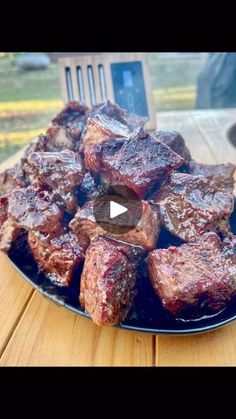 a plate full of meat sitting on top of a wooden table