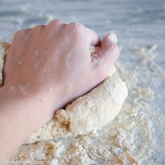 a person is kneading dough on top of it in the middle of some flour