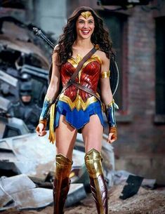 a woman dressed as wonder, standing in front of rubble