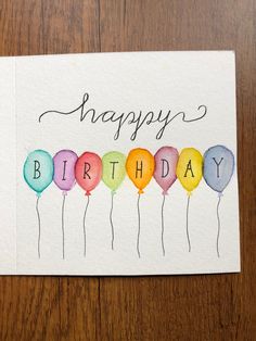 a happy birthday card with watercolor balloons and the words happy birthday written on it