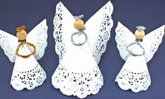 three white angel figurines with rings on them