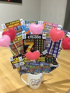 a coffee cup filled with valentine's day cards and pink heart shaped felt hearts