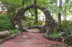 a stone arch in the middle of a garden