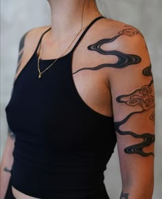 a woman with tattoos on her arm and shoulder