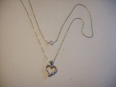 "This beautiful classic and delicate heart pendant has a row of rhinestones on the right side and polished silver on the left. It is a sparkling heart that measures 1/2\" wide by 3/4\" tall (includes bail) and is connected to a  20 1/4\" fine Box Sterling chain. It is in excellent condition and has a solid spring ring closure . It would make an excellent any occasion gift and we will mail it to you with Free shipping. We ship only to N. America (Canada-USA) *Please contact us if you wish to buy multiple items so that we can adjust the shipping accordingly." Silver Heart Necklace With Rhinestones, Silver Double Heart Jewelry With Rhinestones, Silver Heart Necklace With Diamond Accents For Formal Occasions, Star Watch, Art Nouveau Pendant, Glass Bangles, White Pearl Necklace, America And Canada, Rhinestone Bracelet