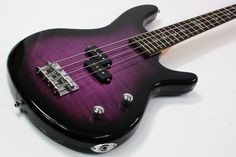 a black and purple bass guitar sitting on top of a table