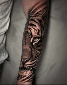 a man's arm with a tiger tattoo on it and the image is in black and white