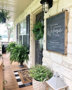 the front porch is decorated with potted plants and an old fashioned sign that says farmhouse charm