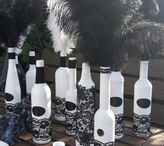 there are many bottles that have been decorated with black and white laces on them