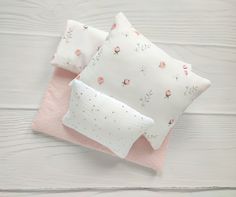 three pillows with pink and white flowers on them