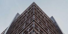 a very tall building with many windows on it's sides and the sky in the background