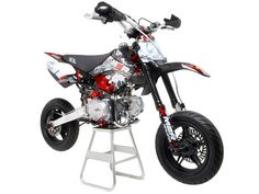 a small dirt bike is shown on a white stand with black and red paint scheme