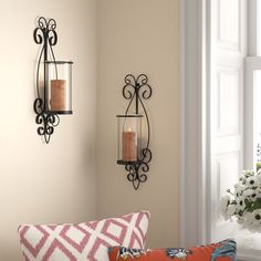 a living room filled with lots of furniture next to a wall mounted candle holder and window