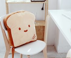 a toaster shaped pillow sitting on top of a chair in front of a computer desk