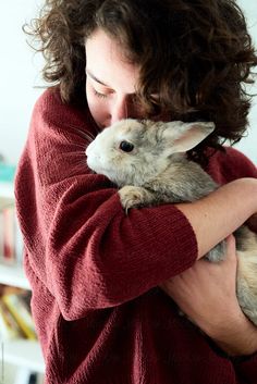 a woman holding a rabbit in her arms