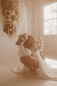 a woman kneeling down with flowers in her hair