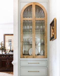 a china cabinet with glass doors and drawers