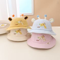 This adorable hat features cute giraffe ears on top, adding a playful touch to their outfit. Made from lightweight and breathable fabric, it provides excellent sun protection while keeping your child cool and comfortable. The wide brim offers extra shade for their face and neck, making it perfect for outdoor adventures. Material: Cotton. Color: Beige, Yellow, Dark Pink, Light Pink, Blue. Giraffe Ears, Baby Bucket Hat, Cartoon Giraffe, Bucket Cap, Giraffe Pattern, Baby Sun Hat, Cartoon Embroidery, Visor Cap, Cute Giraffe