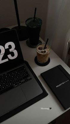 an open laptop computer sitting on top of a desk next to a cup of coffee