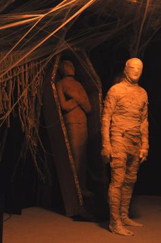 a man standing in front of a mirror next to another person wearing a body suit